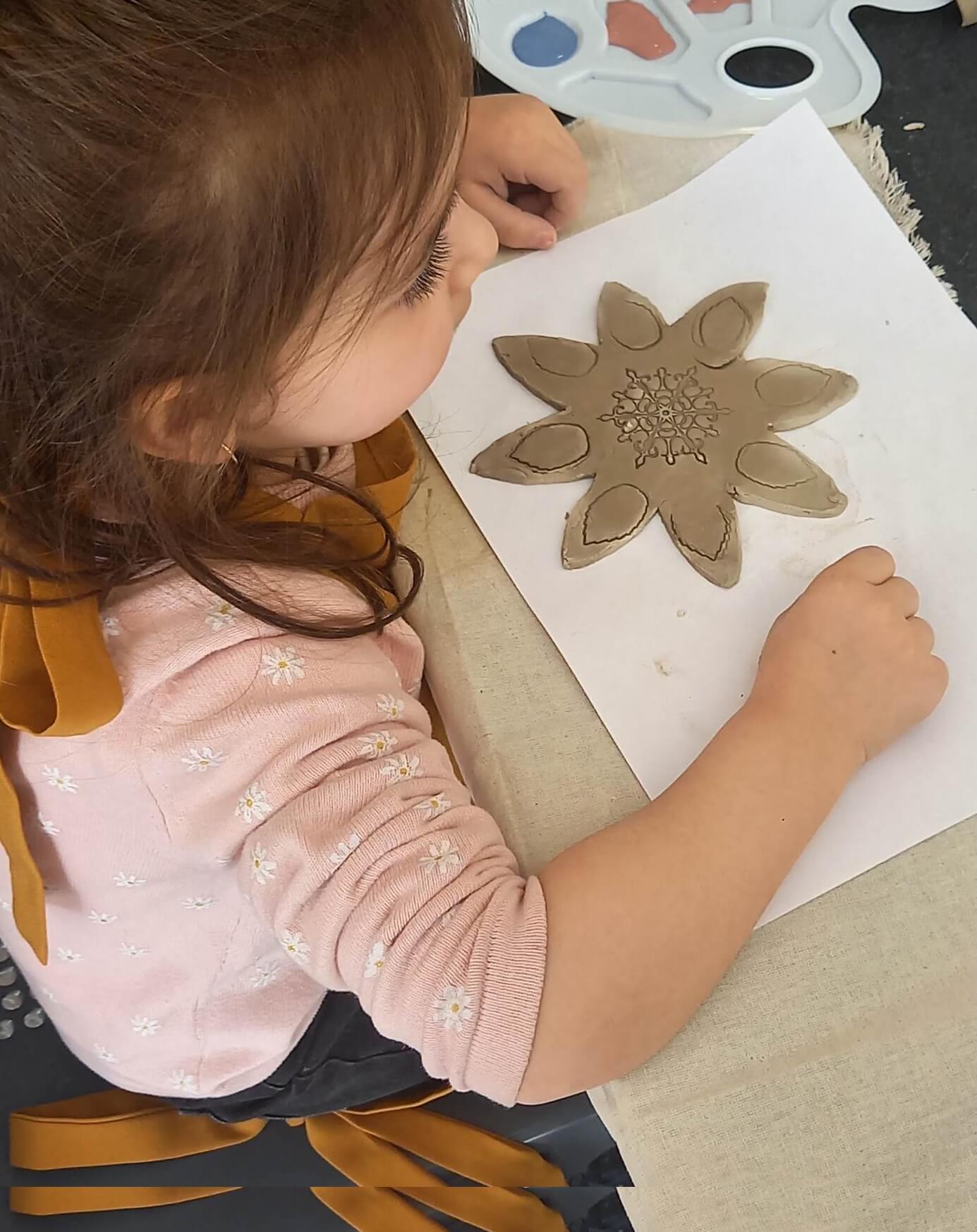 A young artist decorates a ceramic star